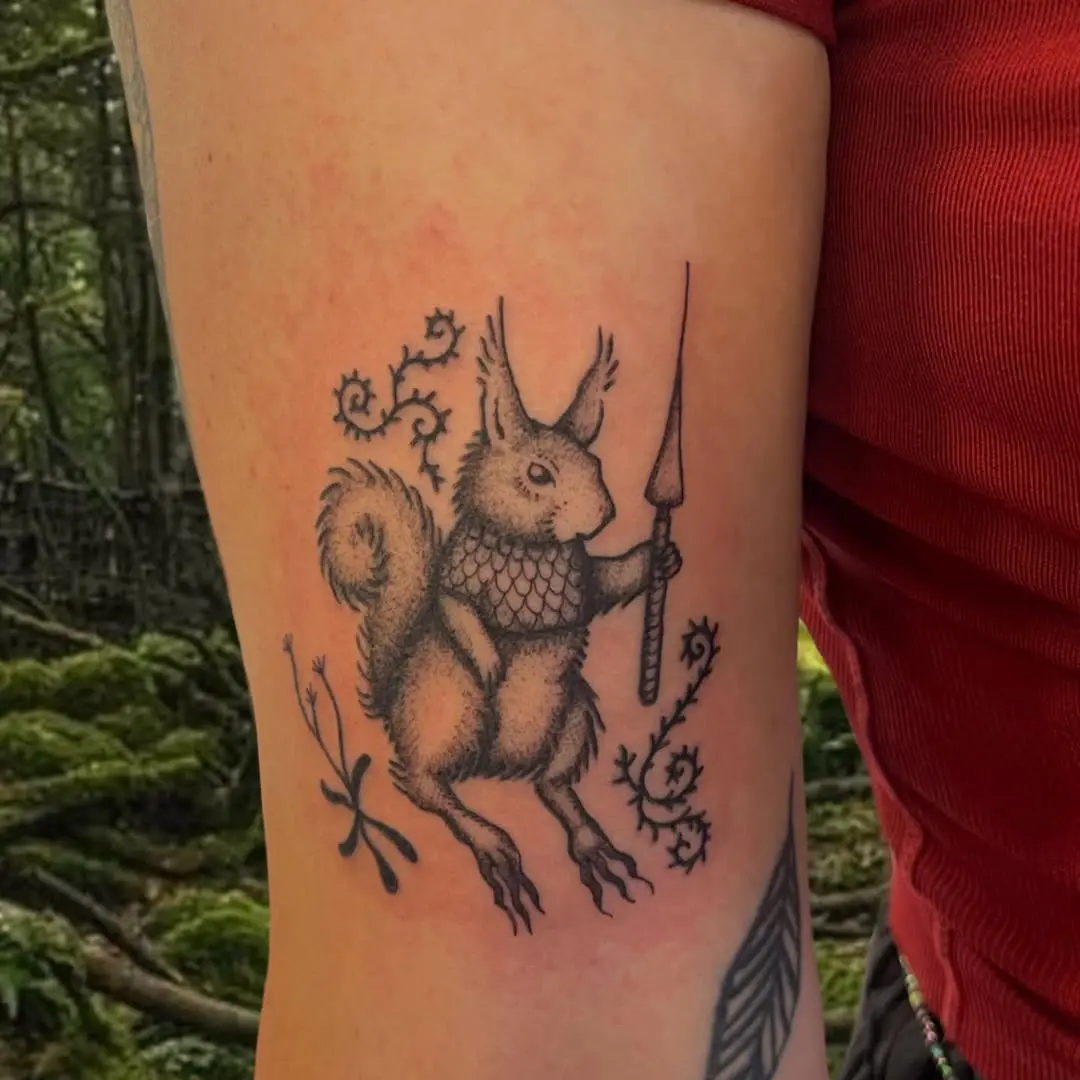 A whimsical squirrel holding a spear tattoo