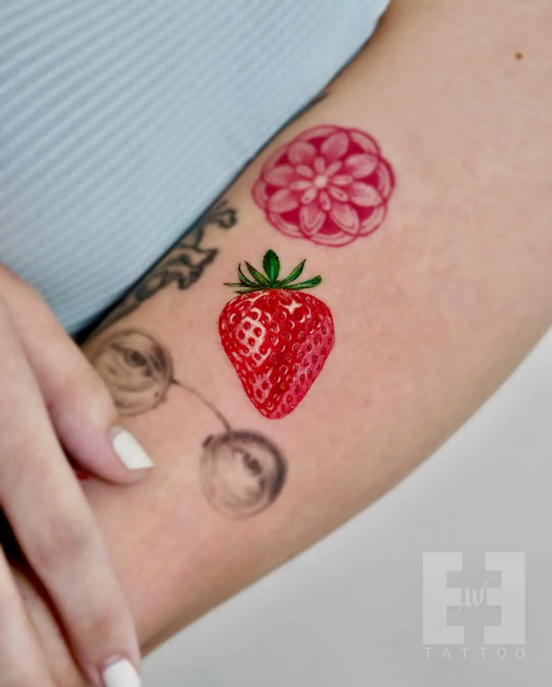 Vibrant strawberry and floral tattoo duo