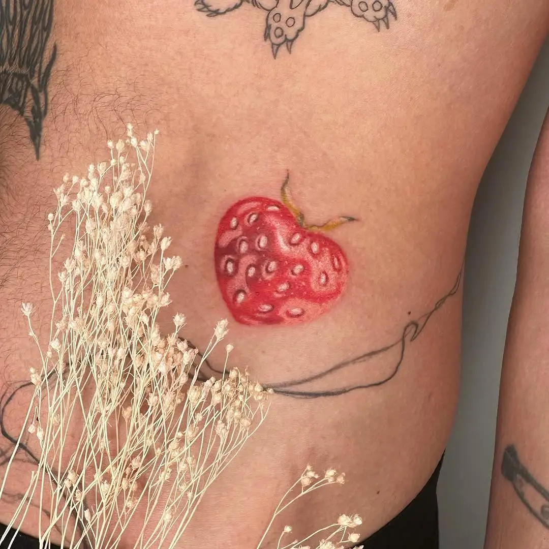 Colorful strawberry tattoo on the side body