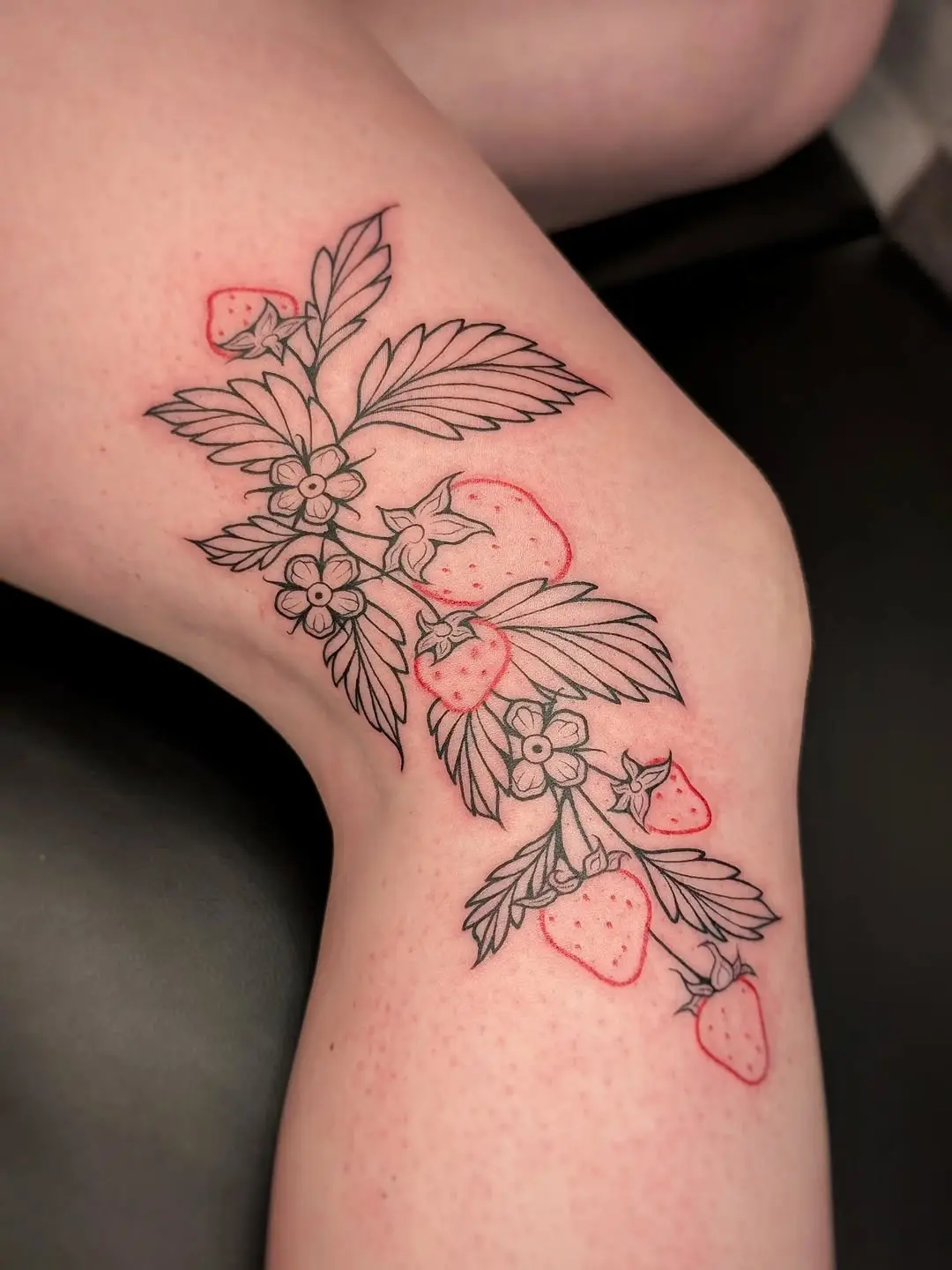 Elegant strawberry tattoo with floral elements