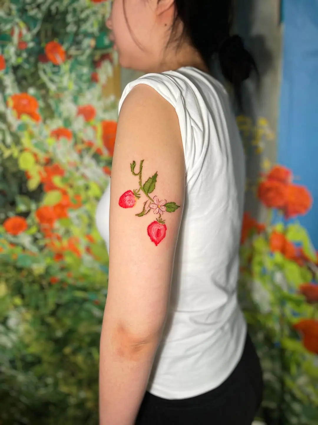 Vibrant strawberry tattoo with floral accents