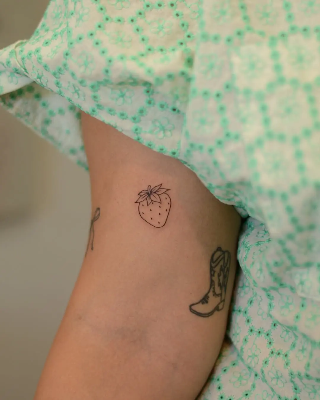 Minimalistic strawberry tattoo on inner arm