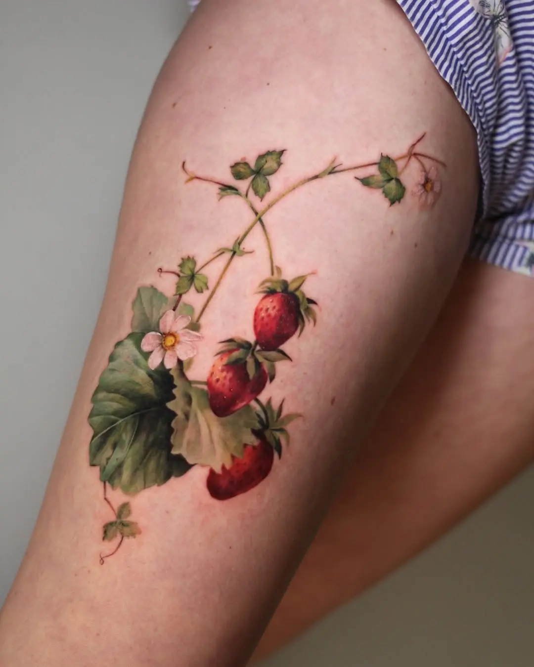 Vivid Strawberry Tattoo with Floral Accents