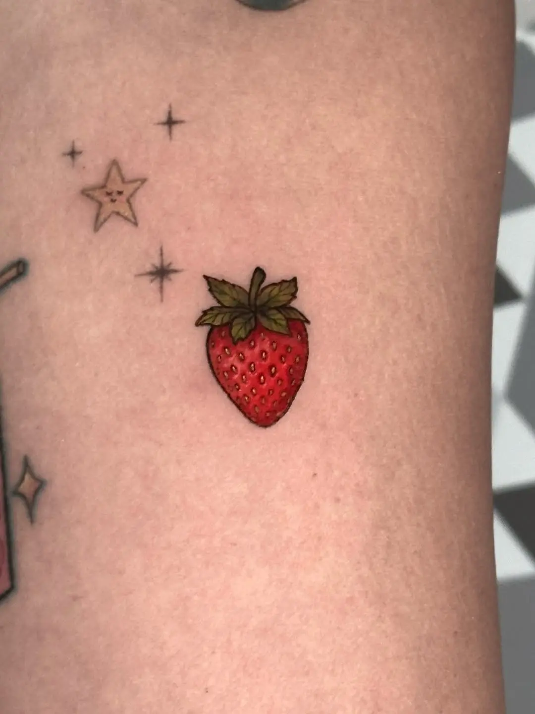 Whimsical Strawberry Tattoo Amidst Stars