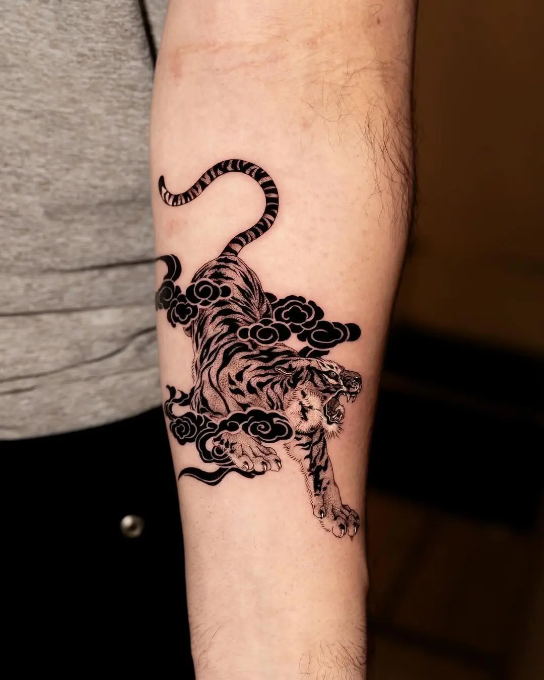 Dynamic tiger tattoo emerging from billowing clouds