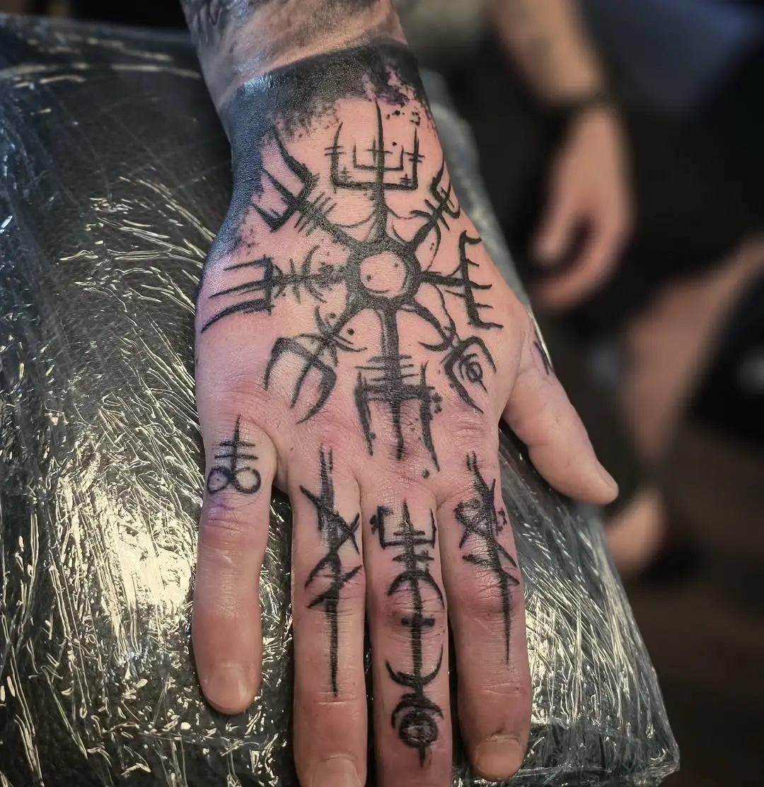 Intricate Viking Symbols on Hand Tattoo