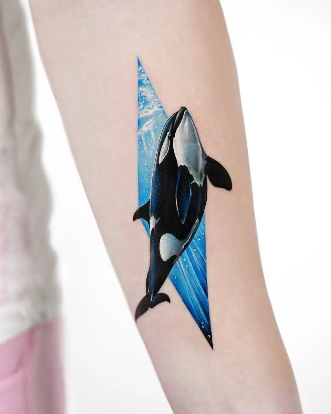 Striking orca tattoo blending with ocean waves
