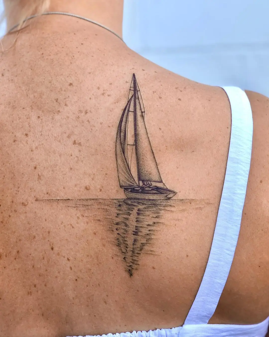 Elegant sailboat tattoo with serene waves