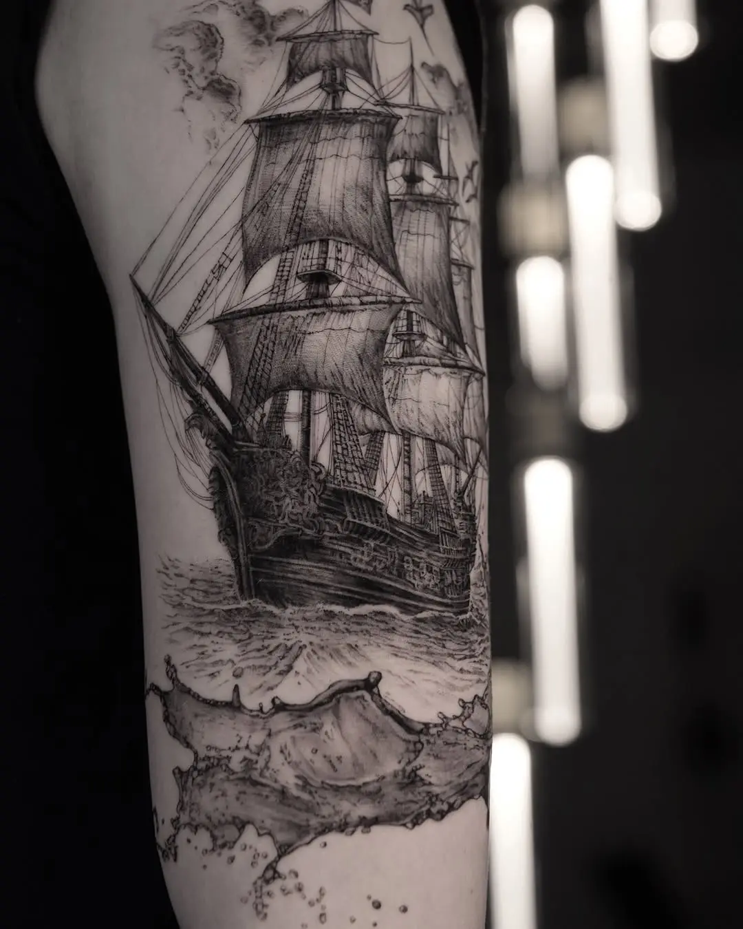 Intricate sailing ship tattoo with waves