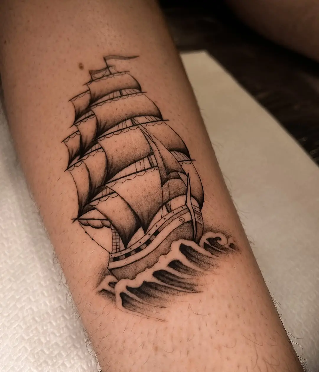Elegant sailing ship tattoo with wave accents