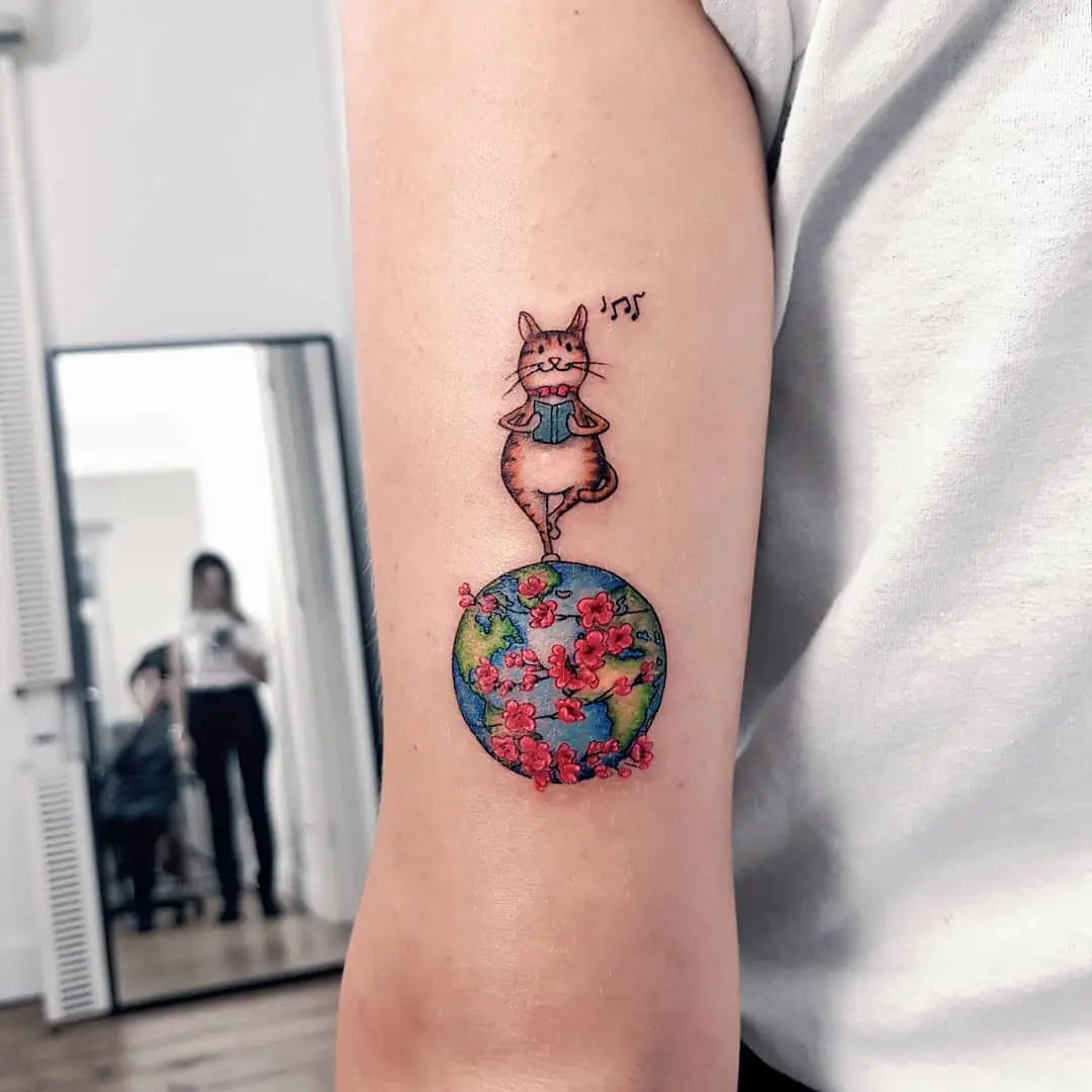 Whimsical cat tattoo on a vibrant globe