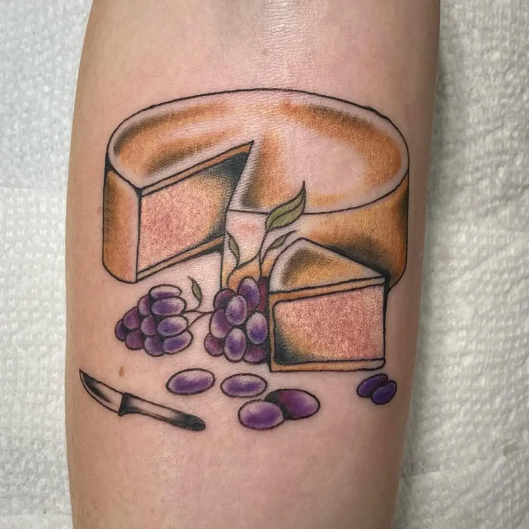 A delicious cheese tattoo with grapes and knife