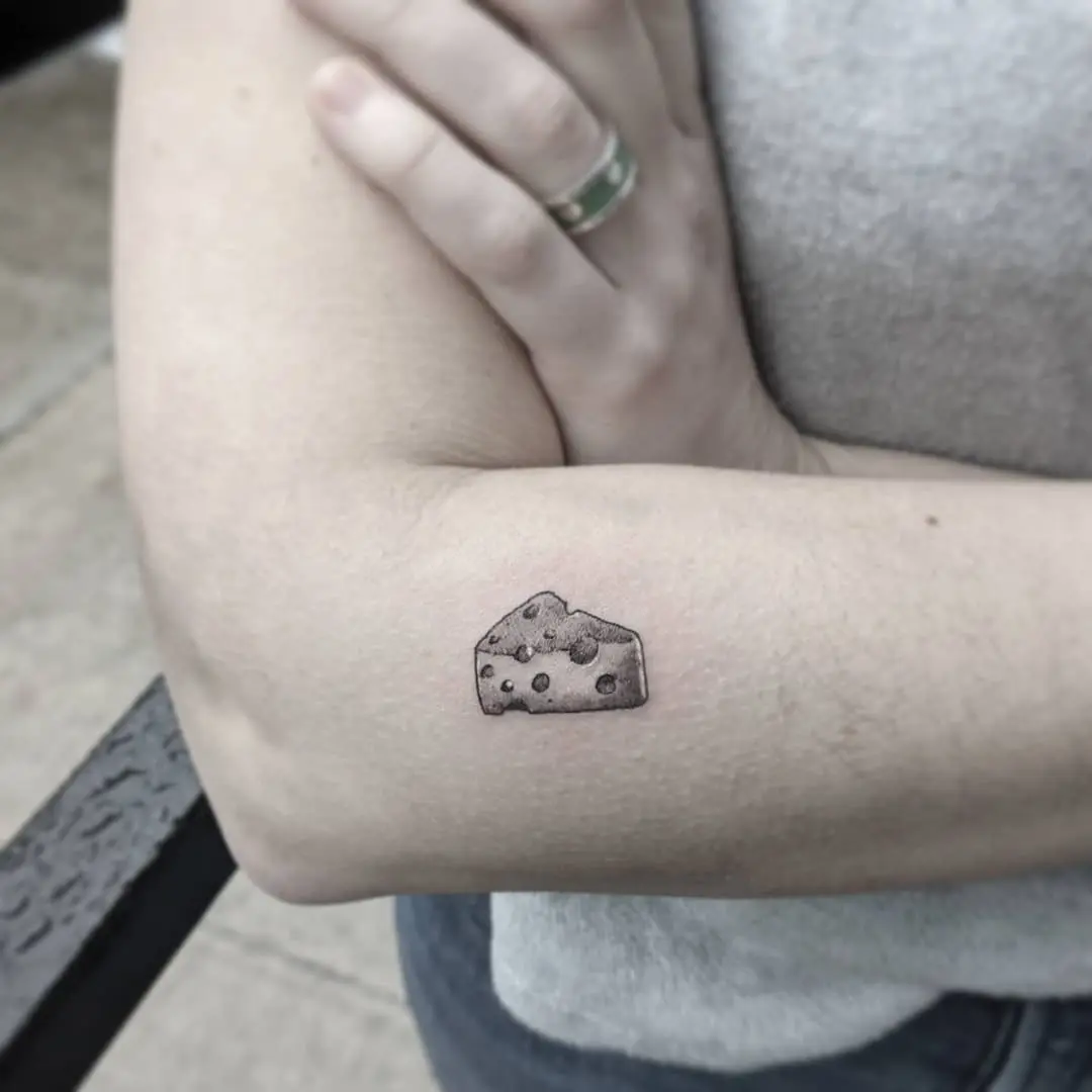 Realistic cheese tattoo on an arm