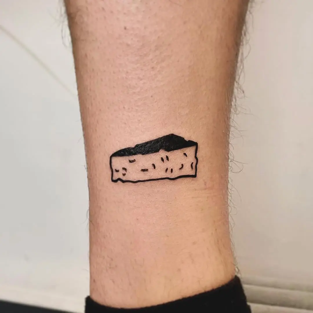 A whimsical cheese tattoo on the ankle.