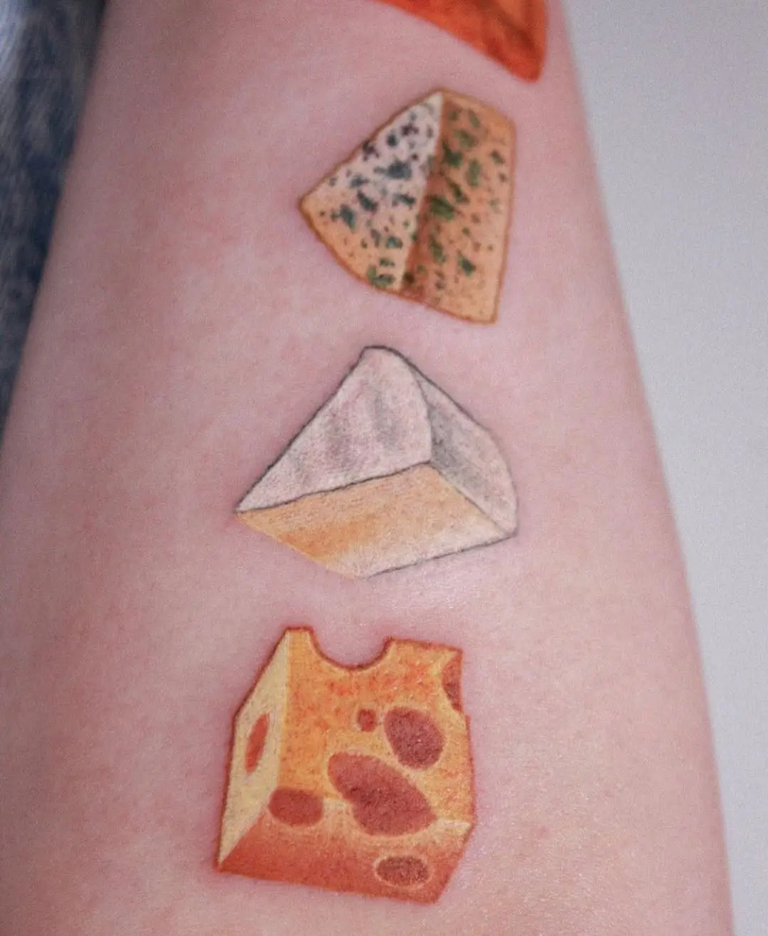 Colorful tattoo interpretations of beloved cheeses