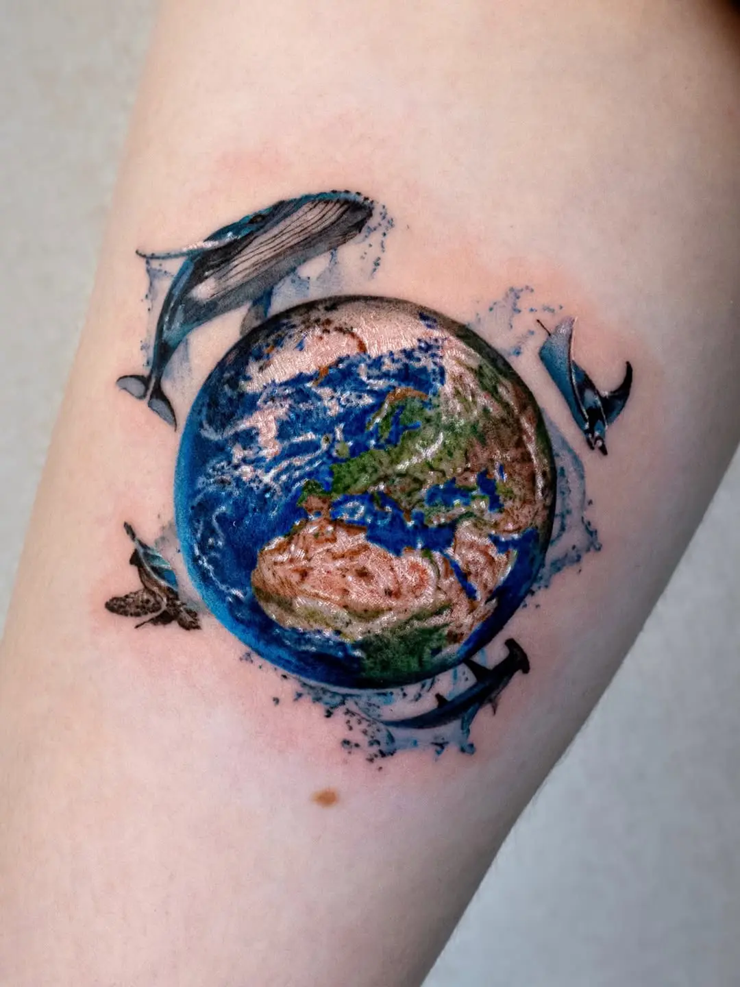 Vibrant Earth Tattoo Surrounded by Marine Life