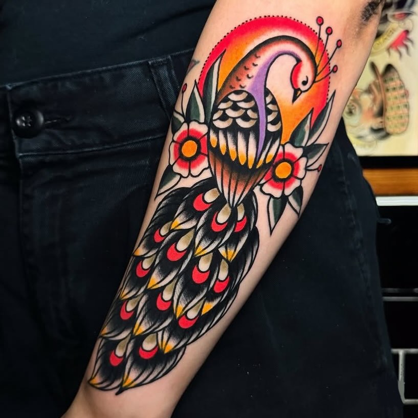 Vibrant peacock tattoo with floral accents