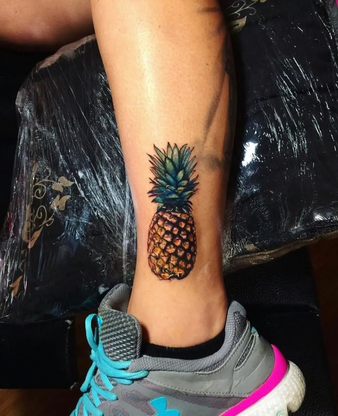 Vibrant pineapple tattoo on athletic leg