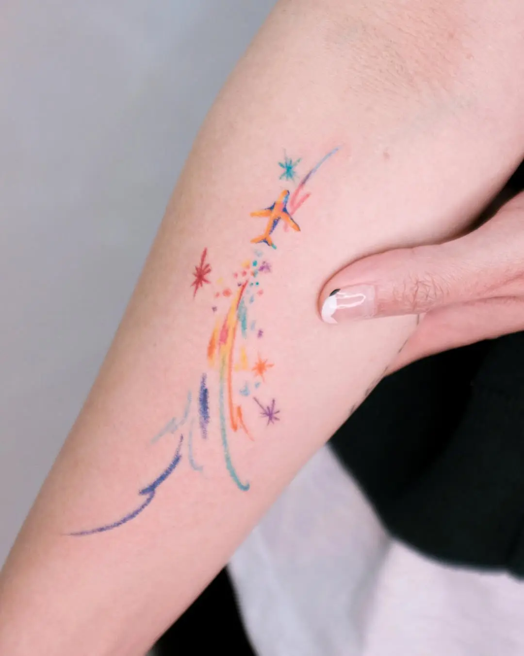 Colorful shooting star tattoo on the arm