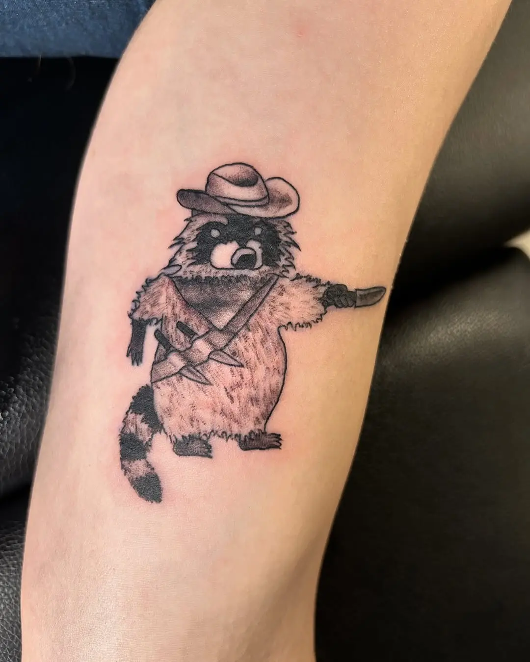 Whimsical cowboy raccoon tattoo with attitude