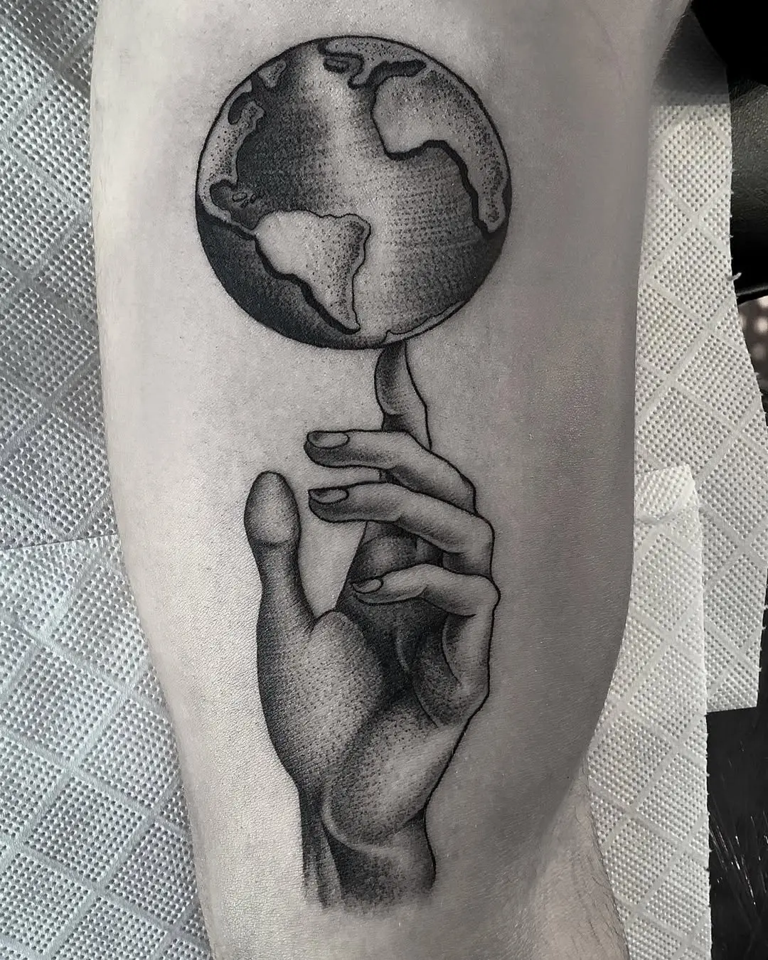 Earth and hand tattoo conveying connection