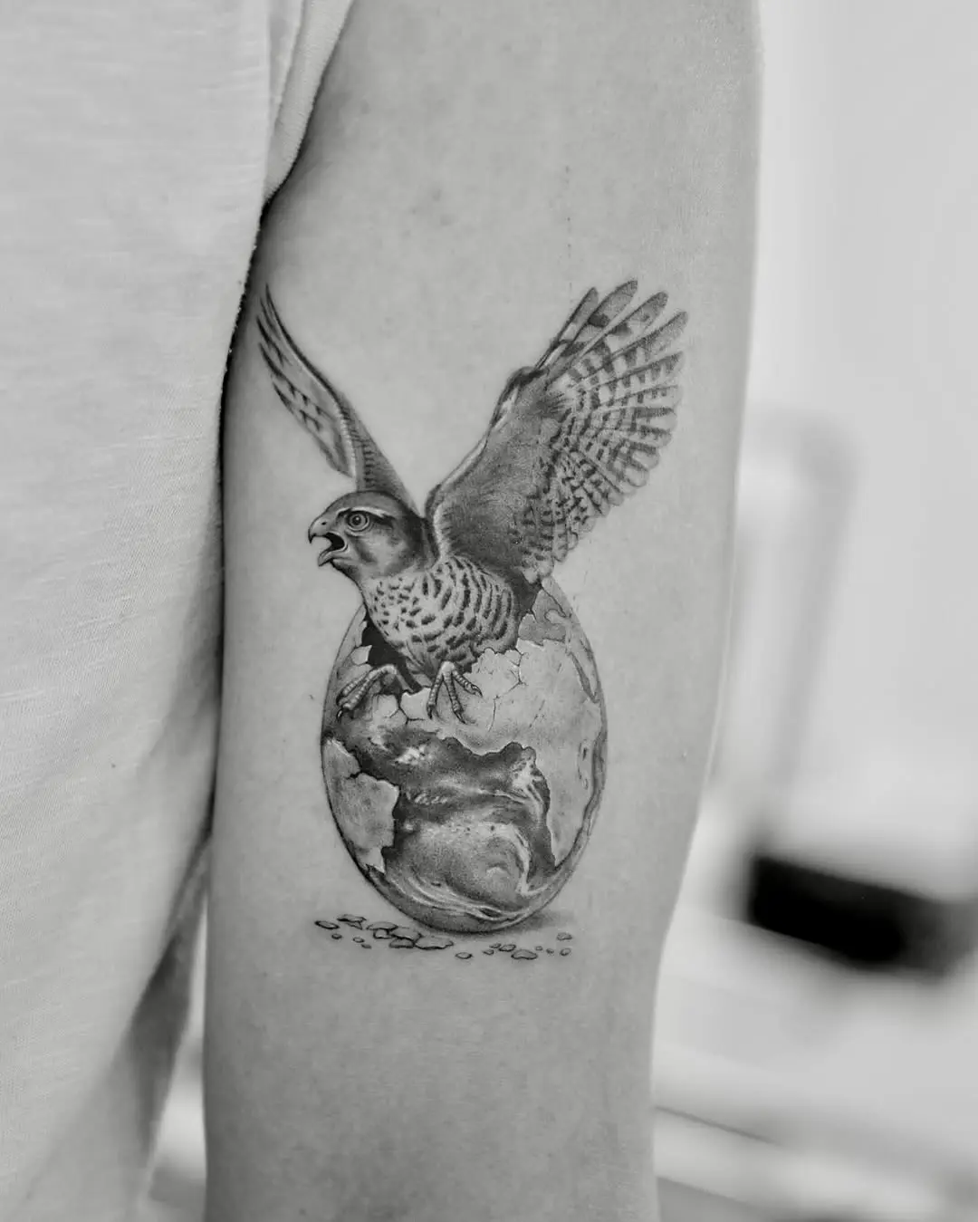 Majestic falcon soaring over the earth tattoo