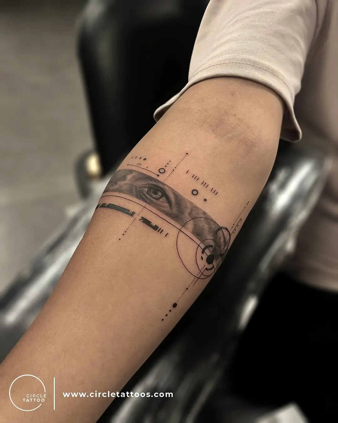 Intricate geometric armband tattoo featuring an eye