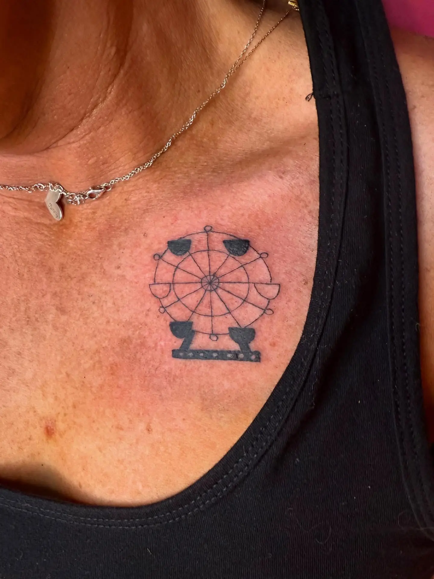 Minimalistic ferris wheel tattoo on collarbone