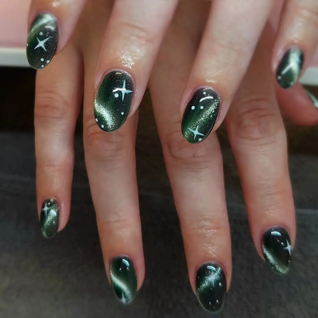 Stunning galaxy nail design in deep green tones