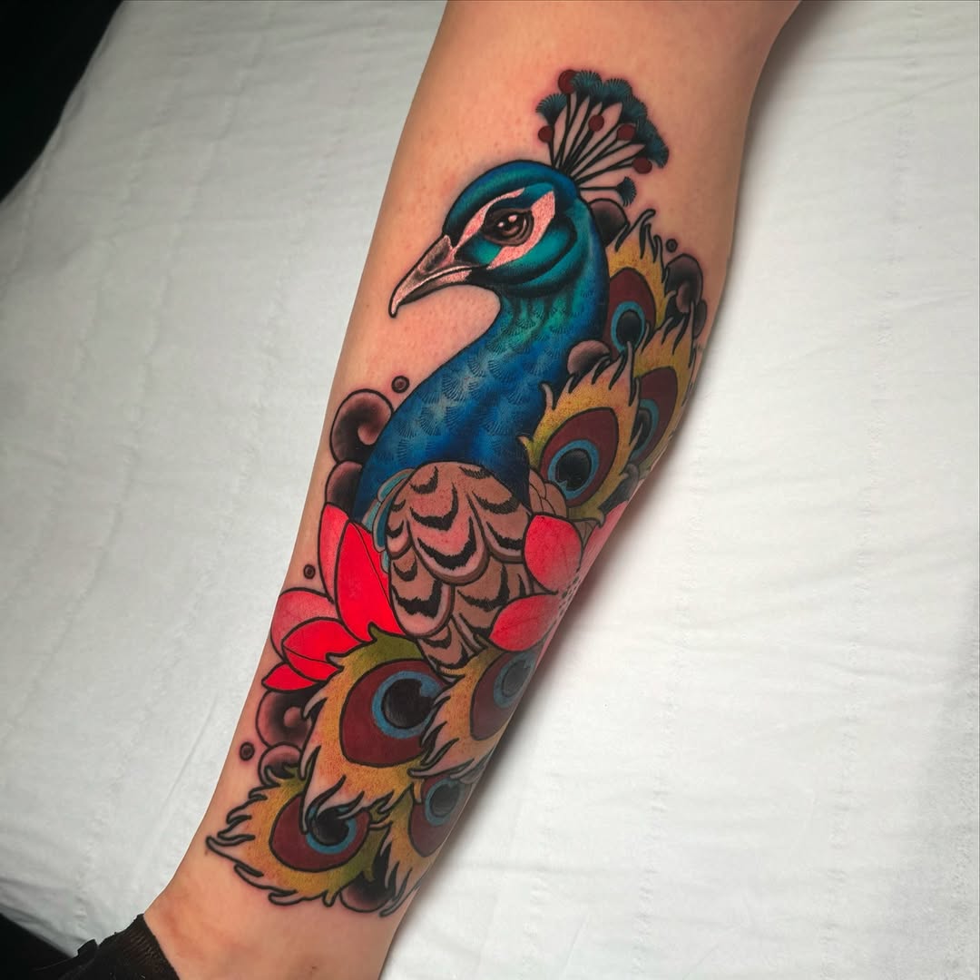 Vibrant peacock tattoo with floral elements