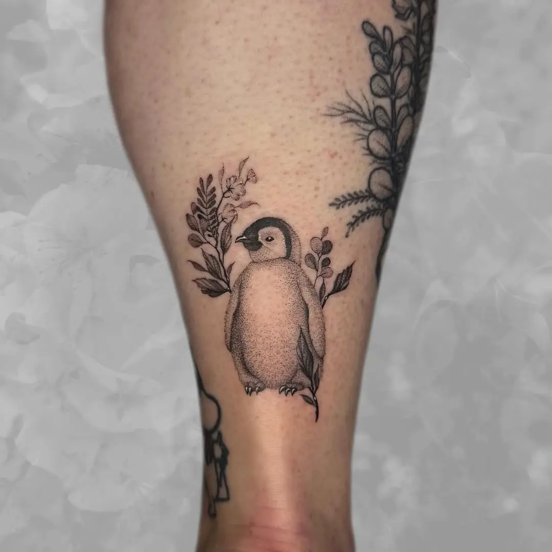 Charming penguin tattoo with floral accents