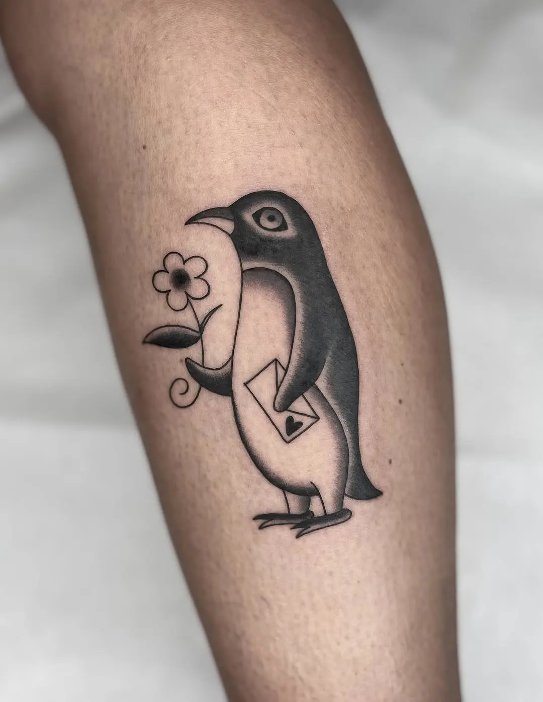 Charming penguin tattoo with flower and letter
