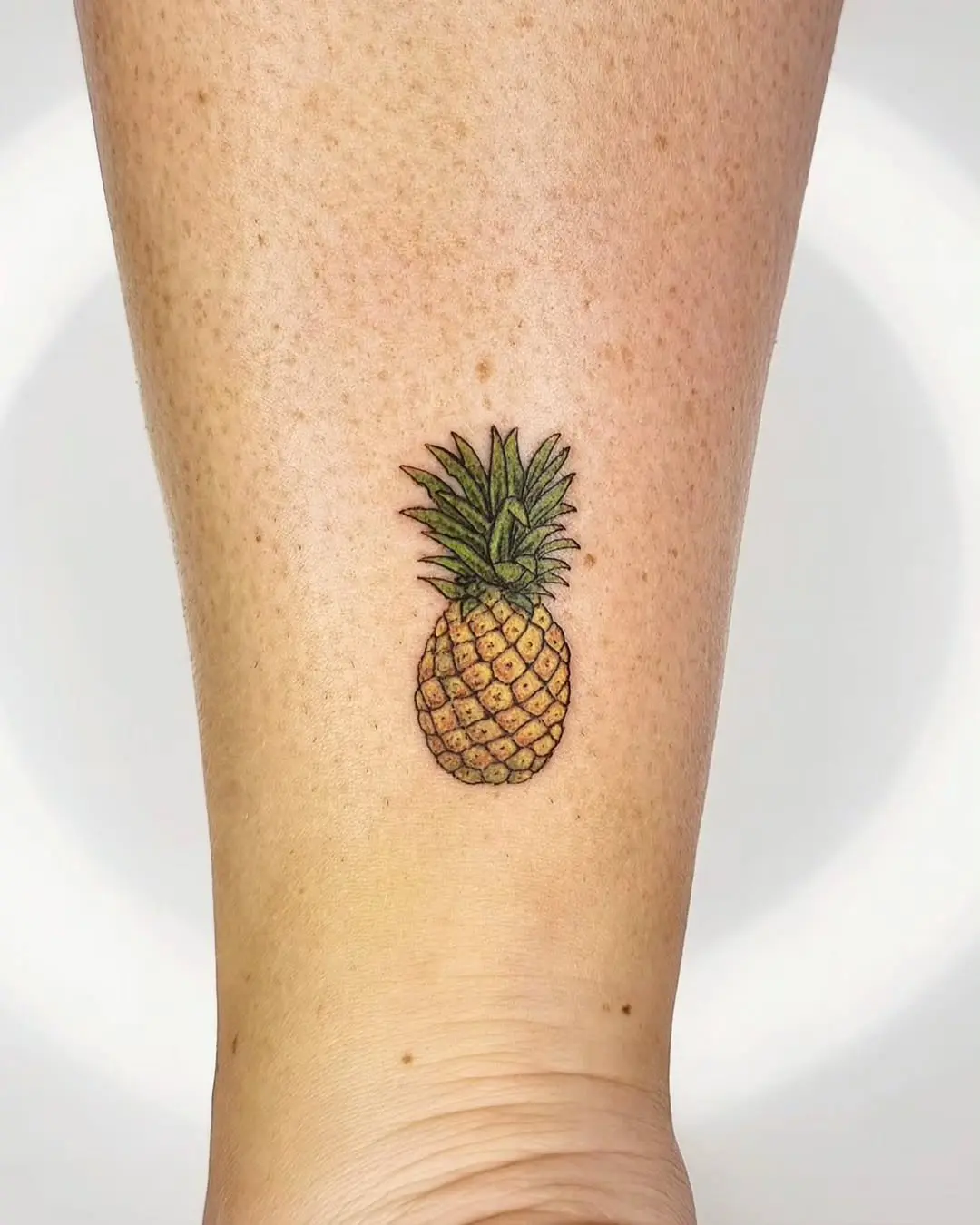 Charming small pineapple tattoo on ankle.