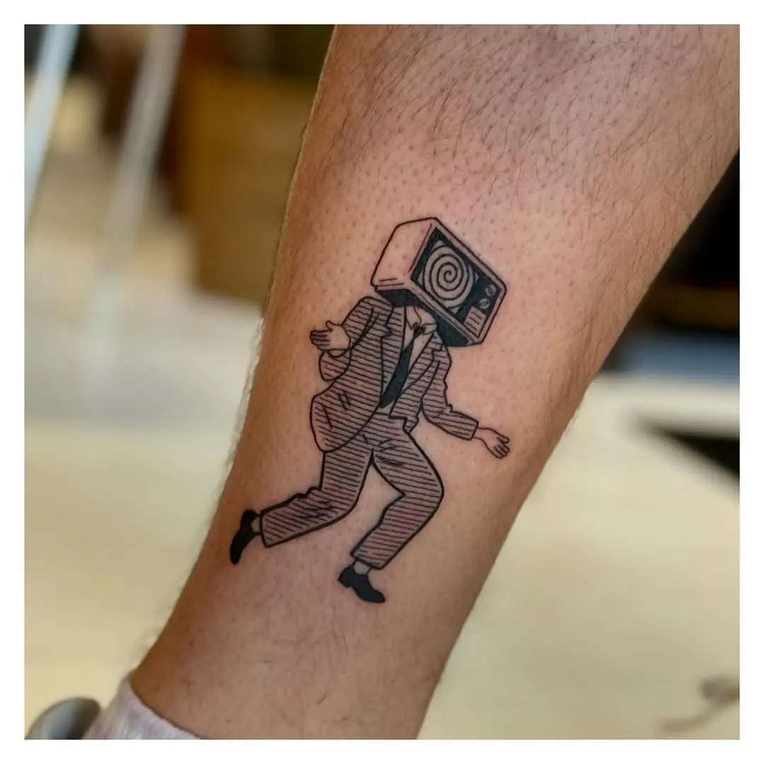 Whimsical tattoo of a suited man with TV head