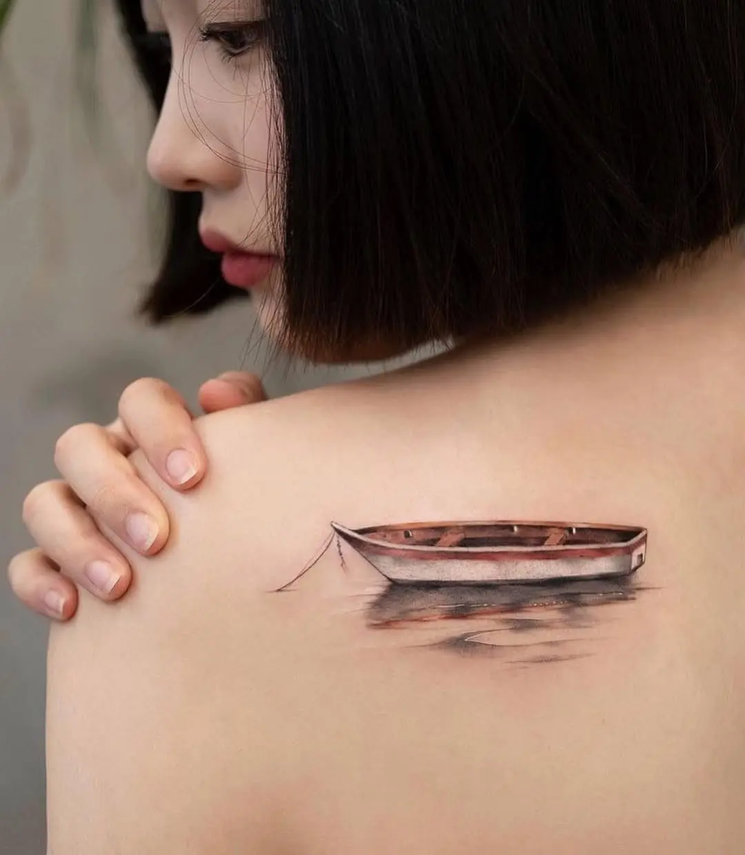A serene boat tattoo on the shoulder