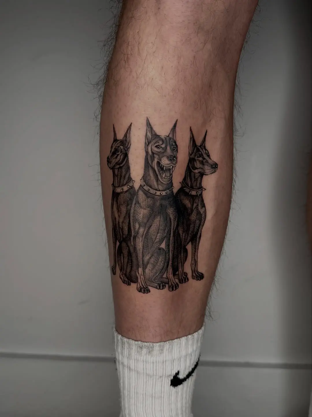 Bold black ink dog tattoo design on shin