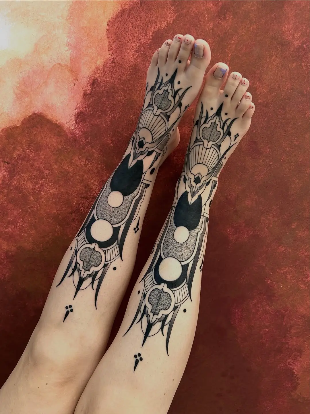 Unique blackwork designs grace the shins