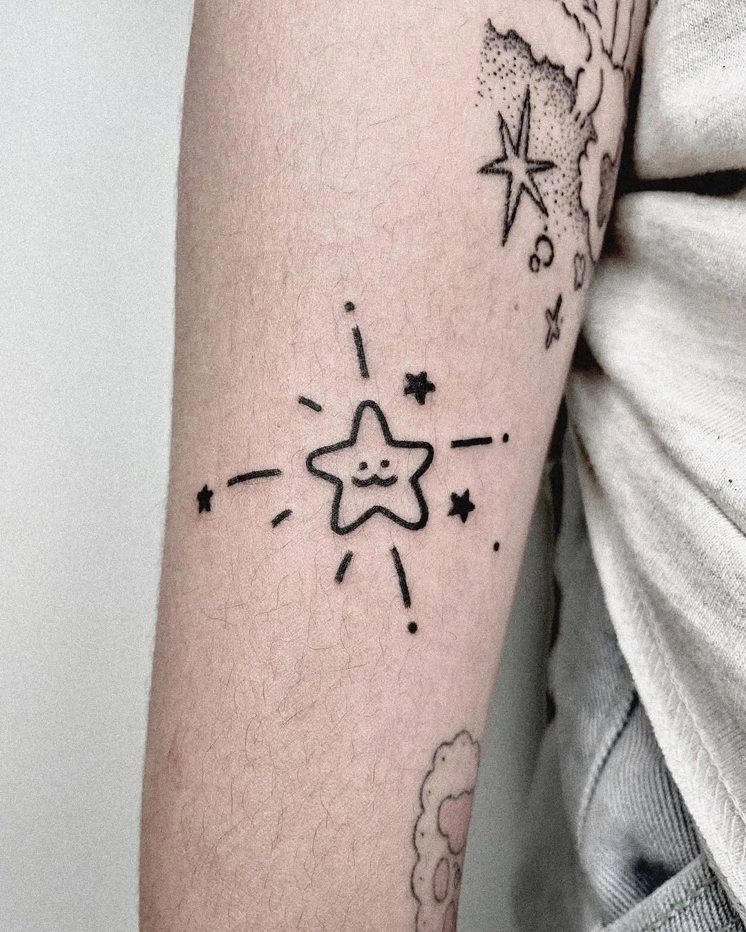 Delicate shooting star tattoo on forearm
