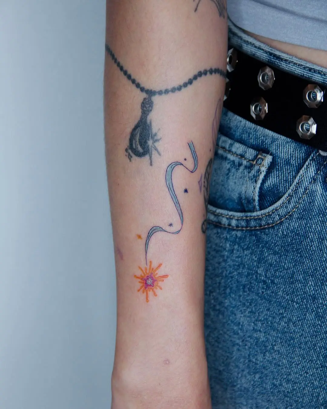 Colorful shooting star tattoo on the forearm