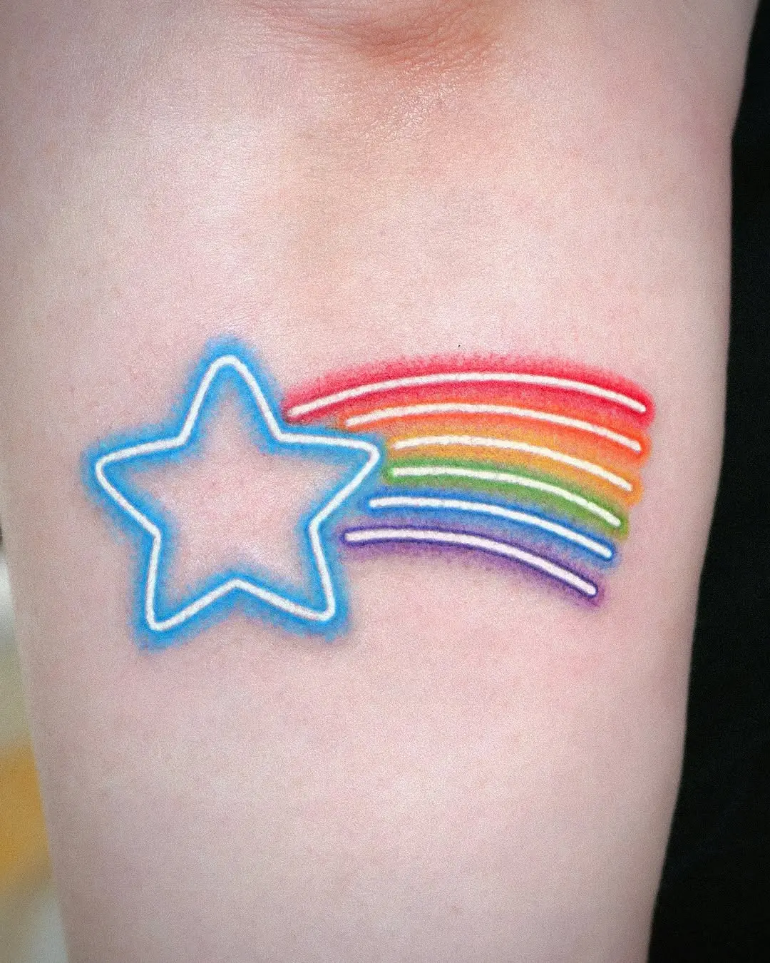 Vibrant shooting star tattoo with rainbow trails