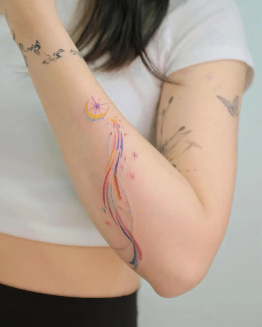A whimsical shooting star tattoo with colorful trails