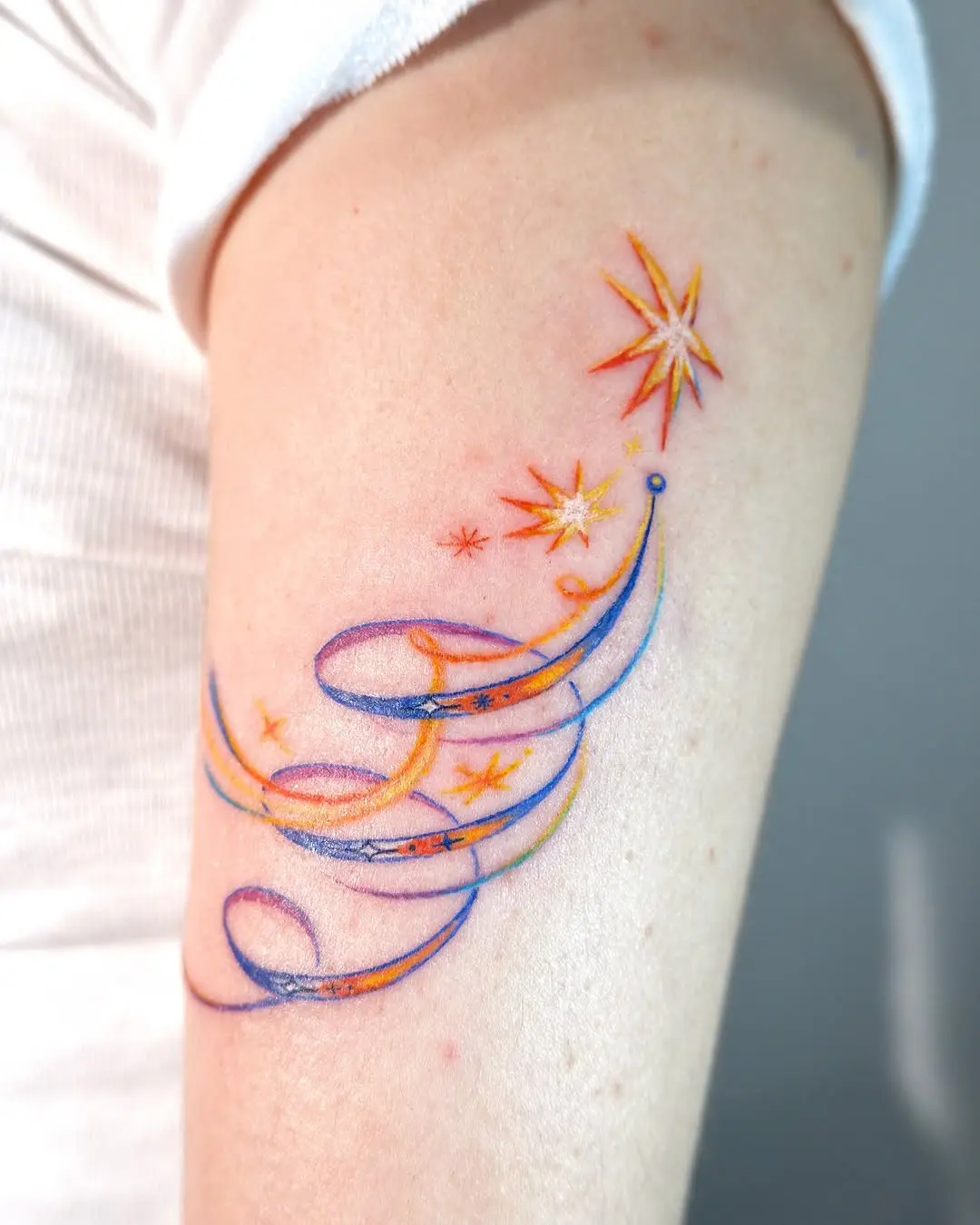 Colorful shooting star tattoo with ribbons