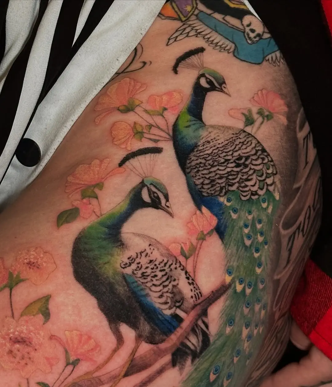 Elegant peacock tattoo with floral accents