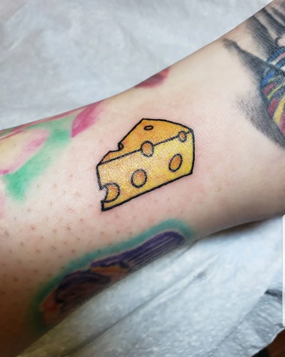 Quirky cheese tattoo with a playful touch