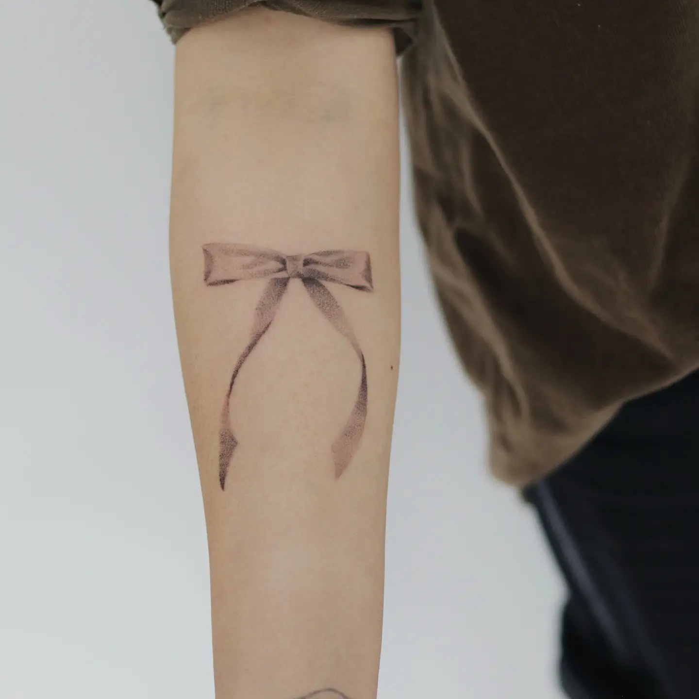 Intricate bow tattoo on the forearm