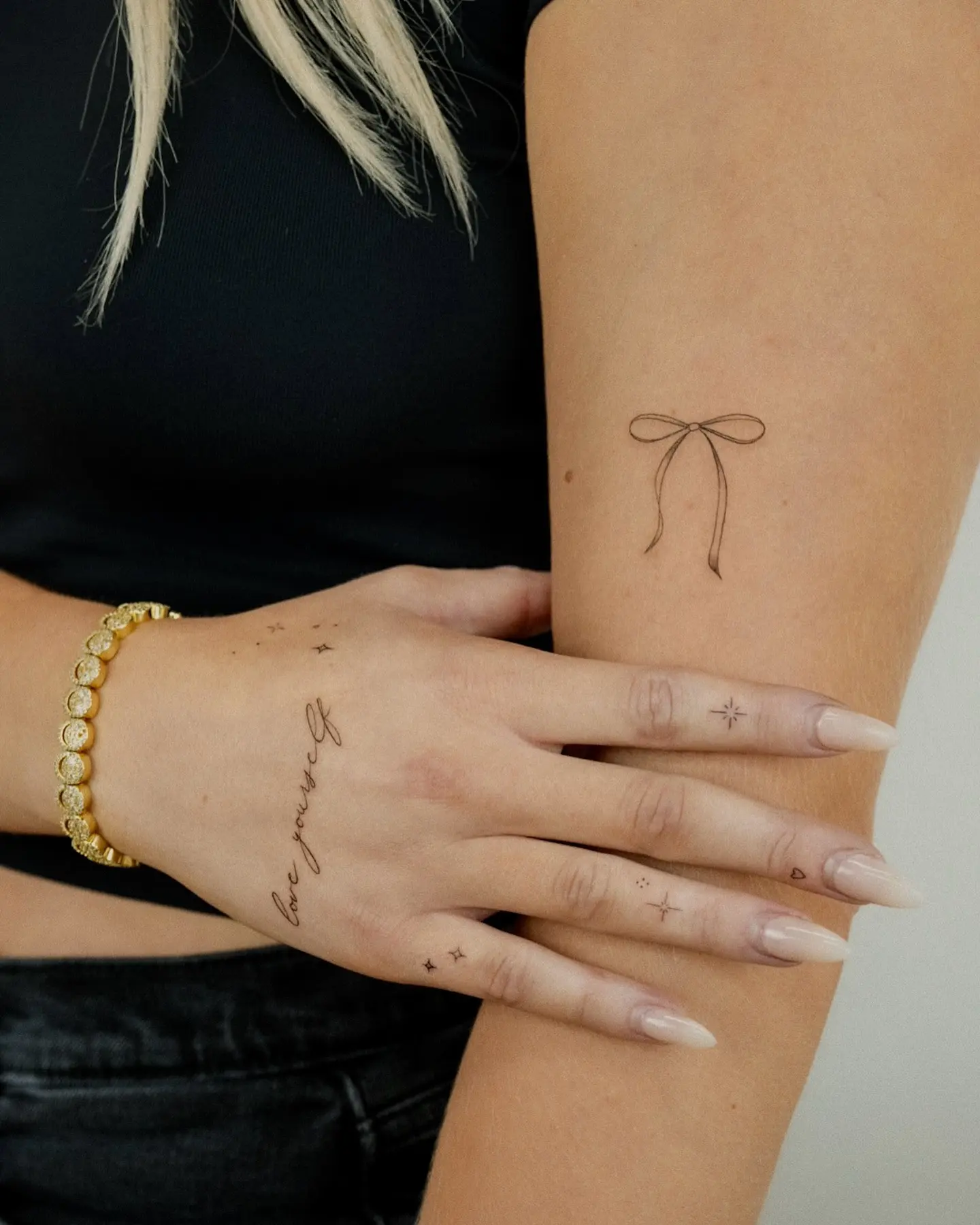 Minimalist bow tattoo with elegant script details
