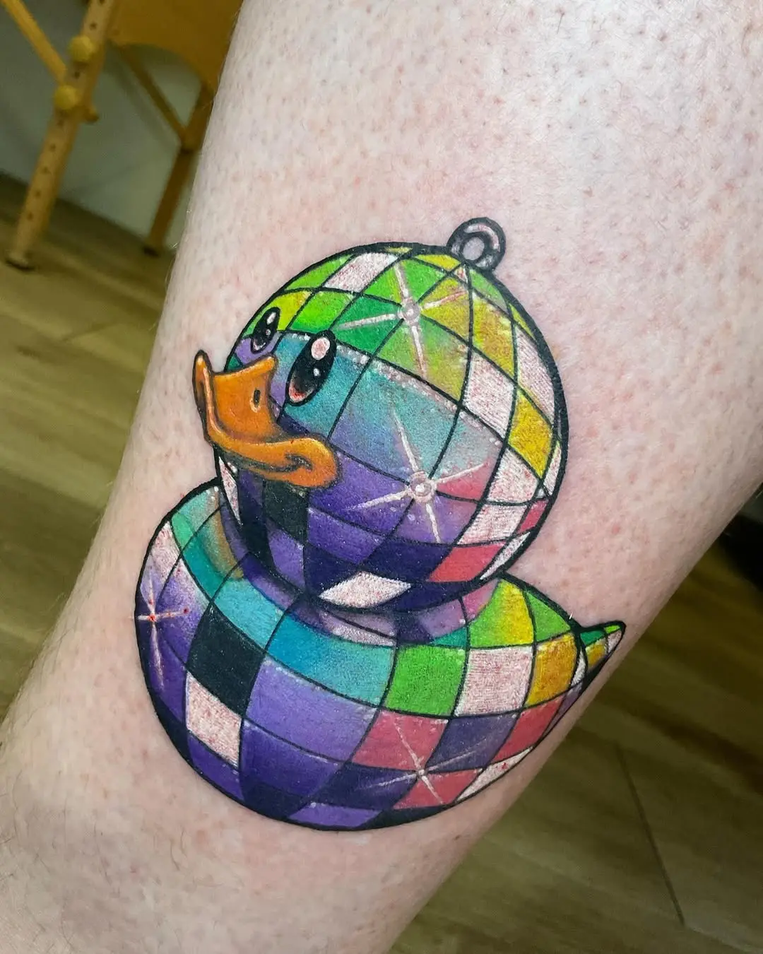 Vibrant disco ball duck tattoo with playful charm