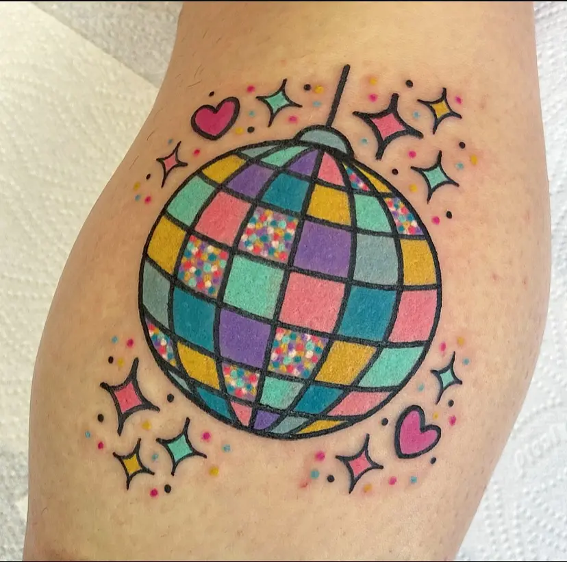 A vibrant disco ball tattoo with playful elements