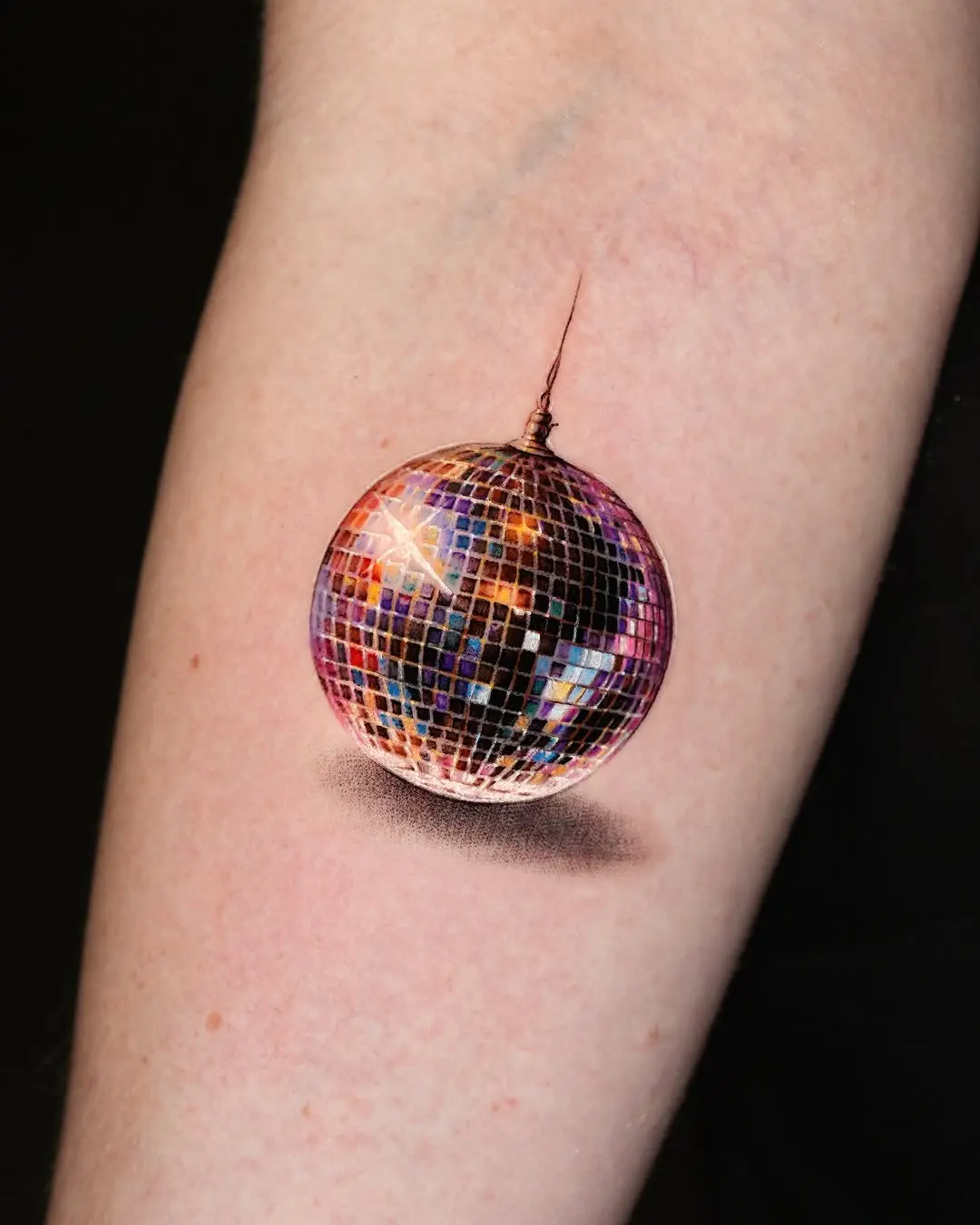 Vibrant disco ball tattoo capturing party vibes