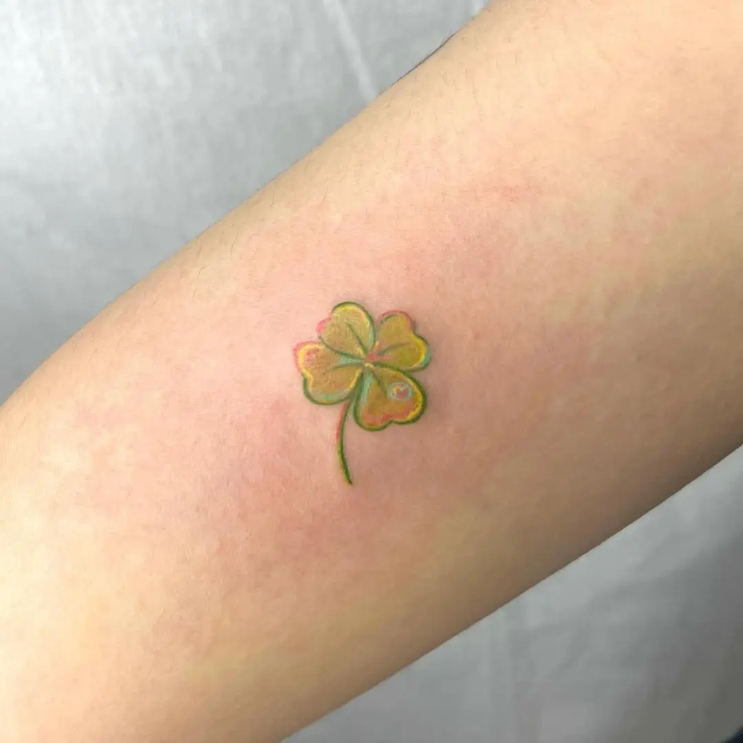 Vibrant four-leaf clover tattoo in pastels